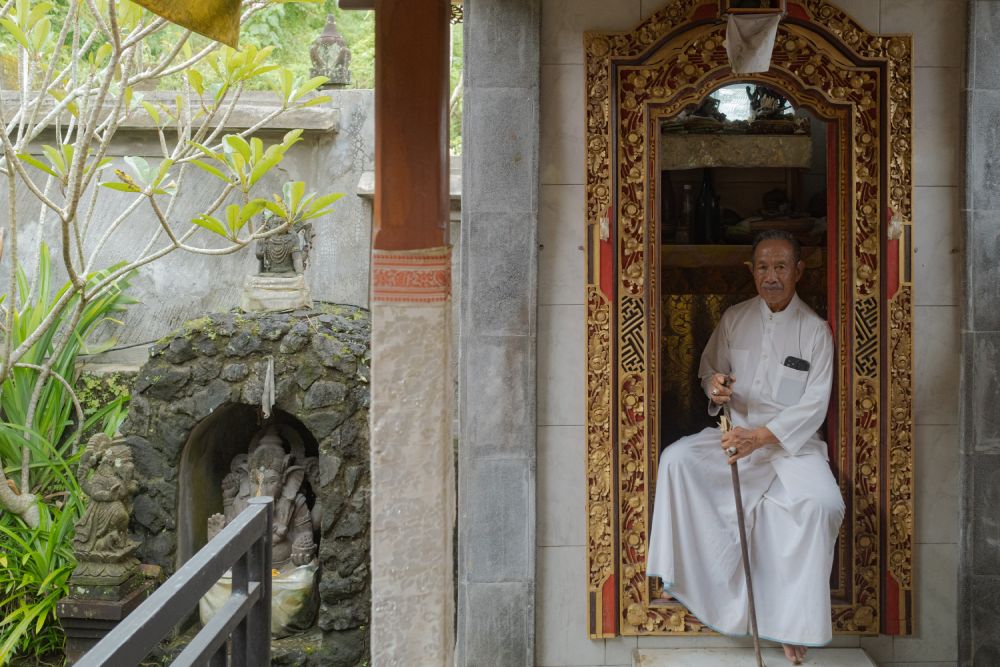 Gusti Nyoman Darta before his sanctified chamber - a sacred space housing an altar dedicated to the Divine and a collection of consecrated artifacts.